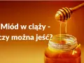 Miód w ciąży - czy można jeść? Słodki, złocisty miód spływa z drewnianej chochli do słoika.