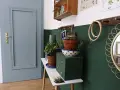 Malowanie drzwi na niebiesko nadało im nowy, świeży wygląd. Wnętrze zdobią rośliny i ozdobne przedmioty.