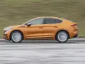 Pomarańczowy elektryczny SUV coupe w ruchu, widok z boku.