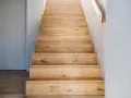 Holztreppe mit beleuchteten Treppenstufen verkleiden. Natürliche Holzmaserung und schlichtes Design.