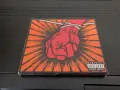 Okładka płyty Metallica "St. Anger" z czerwoną, zawiązaną pięścią i napisem "Parental Advisory".