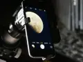Mit dem Handy den Mond fotografieren: Ein Smartphone ist über einen Adapter an einem Teleskop befestigt, um den Mond abzulichten.
