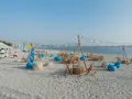 Plaża w Dubaju w lipcu: leżaki, stoliki i girlandy świateł tworzą letnią atmosferę.
