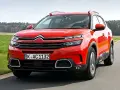 Roter Citroën C5 Aircross fährt auf einer Landstraße. Trotz seines modernen Designs gibt es Berichte über Citroën C5 Aircross Probleme.