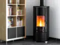 Stufa a pellet moderna con fiamma viva, ideale per dormire con la stufa a pellet accesa in un ambiente accogliente, accanto a una libreria.