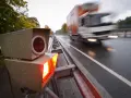 Blitzlicht erhellt die nasse Fahrbahn. Ein LKW rast vorbei. Das Zeugnisverweigerungsrecht bei Blitzern ist ein Thema für Fahrer.