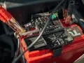 Kable rozruchowe podłączone do czerwonego akumulatora 12V. Zastanawiasz się, jak długo ładować akumulator 12v?
