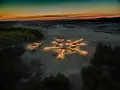 Pustynia Błędowska nocą, rozświetlone domki tworzą kształt gwiazdy. Sprawdź pustynia błędowska cennik, by zaplanować wizytę.