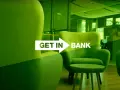 Frankowicze Getin Bank: najnowsze wiadomości o sprawach frankowych. Nowoczesne wnętrze banku z zielonymi fotelami i stolikiem.
