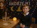 Chłopiec w sweterku i dziewczynka w sukience z gwiazdkami czekają na wróżby. Idealny strój na andrzejki to coś magicznego!
