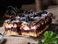 Pyszne ciasto z czarnej porzeczki, z kremem i kruszonką, posypane cukrem pudrem. Idealne na lato!