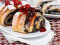 Saftige Mohnschnecken, verziert mit Kirschen und Puderzucker. Ein Genuss, der an die süßen Momente einer Schwangerschaft erinnert.