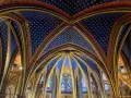 Techo abovedado de la Sainte-Chapelle, con intrincados detalles dorados y un cielo azul estrellado.