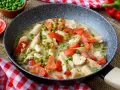 Hähnchen-Curry mit Erbsen und Paprika in cremiger Sauce – ein leckeres und gesundes Mittagessen, serviert in einer Pfanne.