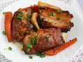 Pyszne, soczyste pieczone żeberka w rękawie z chrupiącą marchewką, posypane szczypiorkiem.