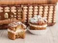 Zwei leckere bienenstich muffins mit Mandel-Topping und cremiger Füllung stehen vor einem Picknickkorb.