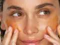 Application d'un masque aloe vera visage. La peau est hydratée et lumineuse, les doigts massent doucement le produit.