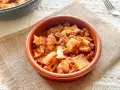 Un cuenco de barro con callos a la vizcaina, un plato tradicional español lleno de sabor y textura.