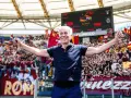 Entrenador sonriente celebra con los aficionados del AS Roma en el Estadio Olímpico.