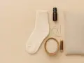Pour savoir comment faire une bouillotte sans bouillotte, voici les ingrédients : une chaussette, du riz, une aiguille, du fil, une petite fiole et un coussin.