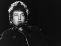 Bob Dylan spielt Mundharmonika, ein wahrer "rolling stone" auf der Bühne, mit seinem charakteristischen Blick.