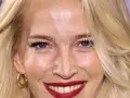 Una mujer sonríe, mostrando cómo cuidar la piel de la cara a los 50 con una piel radiante y maquillaje impecable.