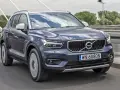 Ciemnogranatowy Volvo XC40 jedzie po moście. Sprawdź aktualną volvo xc40 cena i ofertę.