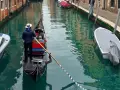 Gondola con gondoliere e passeggeri naviga in un canale veneziano vicino al park sant'andrea venezia.