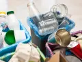 Segregacja odpadów: szklane słoiki, plastikowe butelki i puszki czekają na wywóz śmieci.