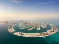 Palma Jumeirah, jedna z najbardziej spektakularnych dubajskich atrakcji, rozpościera się na tle błękitnego nieba i turkusowego morza.