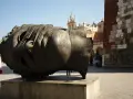 Ogromna, metalowa rzeźba głowy Igora Mitoraja na placu w Krakowie.