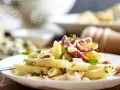 Piatto di pasta porri e salsiccia, cremoso e saporito, con pezzetti di formaggio e erbe fresche.
