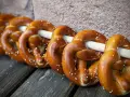 Frisch gebackene Brezeln, perfekt für ein Laugengebäck Rezept. Mit grobem Salz bestreut, liegen sie auf Holzbrettern.