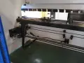 Wnętrze nowoczesnych **pras przemysłowych** z elementami mechanicznymi i prowadnicami.