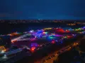 Nocne, kolorowe światła rozświetlają teren festiwalu na powietrzu. Tłumy bawią się pod wielkim, podświetlonym namiotem i na otwartych scenach.