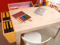 Ein heller Schreibtisch, perfekt zum **schreibtisch selber bauen**, mit Buntstiften, Laptop und Ordnern.