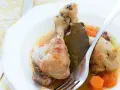 Delicioso pollo guisado con zanahorias y hoja de laurel en un plato blanco, listo para ser disfrutado.