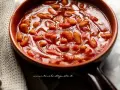Un primo piano di fagioli all'uccelletto in una ciotola di terracotta, un classico delle ricette italiane.