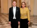 Jonas Vingegaard and his wife, Trine Marie, dressed formally for an event. He wears a tuxedo, and she sports a yellow tweed jacket and pearl necklace.