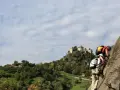 Zwei Kletterer am hoachwool Klettersteig mit Burg im Hintergrund.