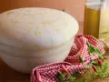 Impasto lievitato per pizza con lievito di birra, soffice e profumato, pronto per essere infornato. Olio e peperoncini completano la scena.