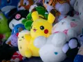 Pluszaki, jak Pikachu i króliczek, czekają na pranie. Kolorowe, miękkie zabawki w różnych kształtach.