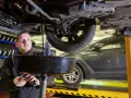 Mechanik spuszcza zużyty olej z samochodu. Zastanawiasz się, ile trwa wymiana oleju i filtrów?