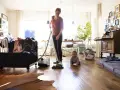 Frau saugt, Baby krabbelt. Wenn der Staubsauger stinkt, was tun? Filter wechseln oder Beutel leeren!