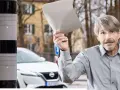 Mann hält Papier hoch, wütend auf Blitzer Arten. Neben ihm ein Messgerät.