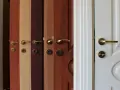 Variedad de tipos de puertas de madera y blancas, con diferentes acabados y manijas doradas.