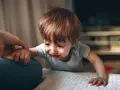 Małe dziecko płacze, a dorosły chwyta je za rękę. Widoczny jest szarpanie dziecka w nerwach.