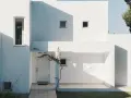 Fachada blanca moderna con sombras marcadas. La mejor pintura para fachadas exteriores protege y embellece esta arquitectura minimalista.