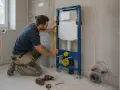 Instalator sprawdza pion przedścianki podtynkowej do WC.