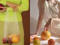 Mani che tengono una mela e una busta con ciliegie e arance. Altre arance e un limone sparsi su uno sfondo chiaro, evocando un'essenza di fruit extract.